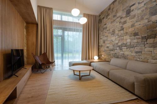 uma sala de estar com um sofá e uma parede de pedra em TALBERG SK - Garage parking - Quiet place - Brand new apartments - Tále em Tale