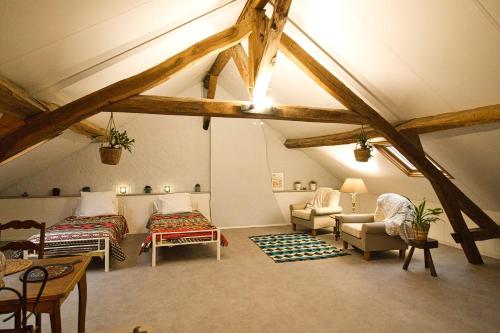 Pokój na poddaszu z 2 łóżkami i kanapą w obiekcie Villa Capucine w mieście Aubigny-sur-Nère
