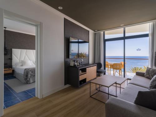 a hotel room with a bed and a living room at Hotel Mirador Papagayo by LIVVO in Playa Blanca