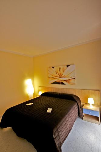 a bedroom with a black bed with two lights on it at Olympo in Bisceglie