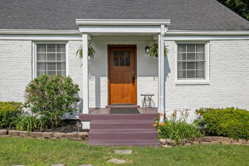 a white house with a brown door and stairs at Neighborhood Retreat, Large Yard Family in Nashville