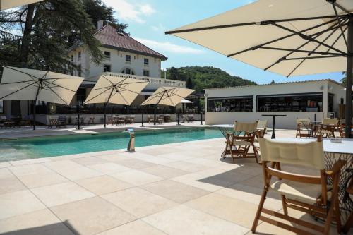 a pool with tables and chairs and umbrellas at Séquoias Golf & Ressort in Ruy