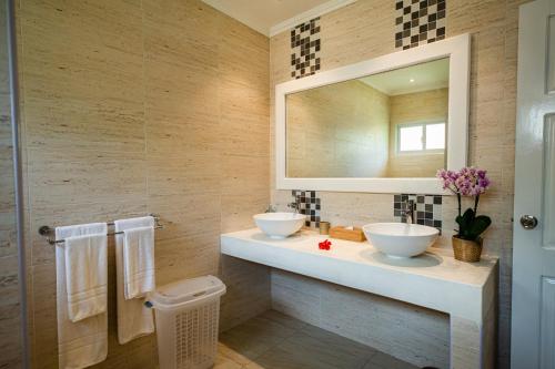 La salle de bains est pourvue de 2 lavabos et d'un miroir. dans l'établissement Anse Boudin Chalets & Villa, à Praslin