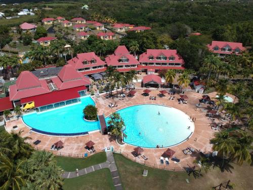 einen Luftblick auf einen Pool in einem Resort in der Unterkunft Le Cocon Créole studio vue mer Village Vacances in Sainte-Anne