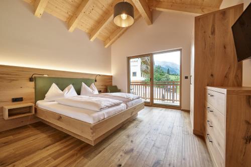 - une chambre avec un lit et une grande fenêtre dans l'établissement Ferienwohnungen Schwabhof, à Kleinarl