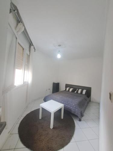 een slaapkamer met een bed en een tafel op een tapijt bij Jolie appartement in Casablanca