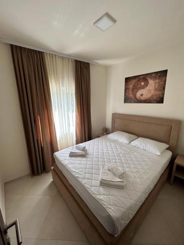 a bedroom with a bed with two towels on it at APARTMENTS TOMIĆ in Bečići