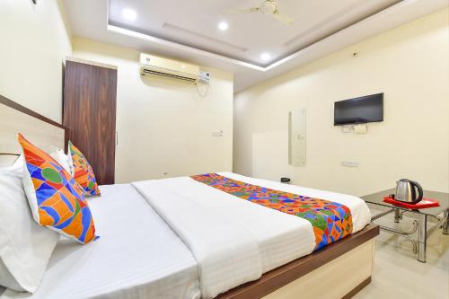 a bedroom with a bed and a tv on the wall at Hotel Pink Cozzy in Jaipur