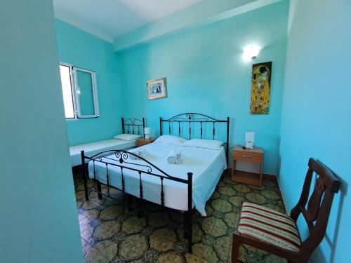a blue bedroom with two beds and a chair at Villa Mele in Lido Marini