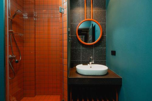 an orange tiled bathroom with a sink and a mirror at Sandali Metekhi Boutique Hotel in Tbilisi City
