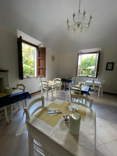 ein Esszimmer mit Tischen, Stühlen und einem Kronleuchter in der Unterkunft Hotel La Marinella in Castiglioncello