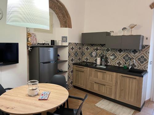 a kitchen with a wooden table and a small table with a table at Appartamento Vaticano in San Vincenzo