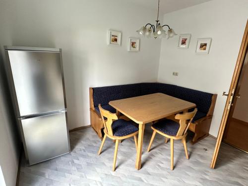 cocina con mesa de madera y nevera en Haus Sonnenspitze - Fam. Nessler, en Biberwier