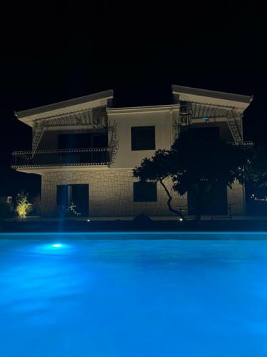 ein Haus in der Nacht mit Pool davor in der Unterkunft Villa Dolina in Opuzen
