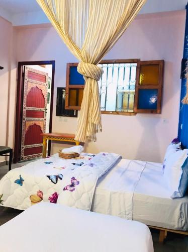 - une chambre avec 2 lits et une fenêtre dans l'établissement Dar MTOGUI, à Rabat