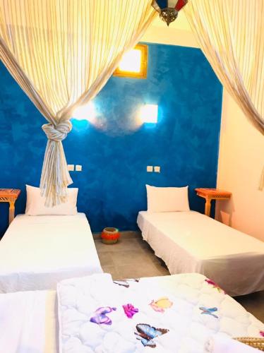 Duas camas num quarto com paredes azuis em Dar MTOGUI em Rabat