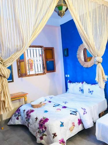 - une chambre dotée d'un lit avec un mur bleu dans l'établissement Dar MTOGUI, à Rabat