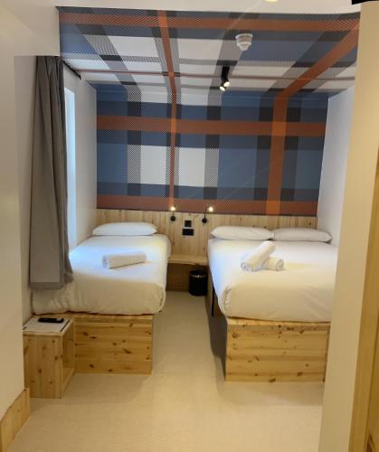 um quarto com duas camas e uma parede listrada em easyHotel Paddington em Londres