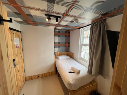 a small room with a bed and a window at easyHotel Paddington in London