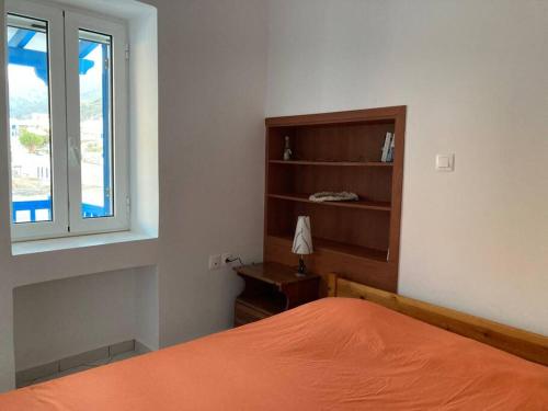1 dormitorio con cama de color naranja y ventana en Walk on the beach in seconds - Studio with Apollon beach view balcony en Apollon