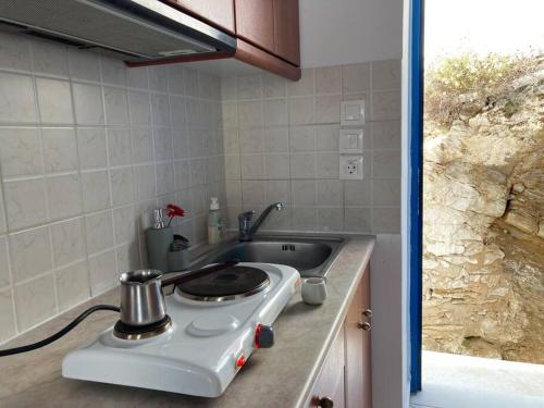 a kitchen counter with a stove and a sink at Walk on the beach in seconds - Studio with Apollon beach view balcony in Apollon