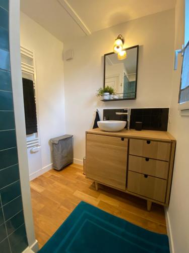 une salle de bain avec un lavabo et un miroir dans l'établissement Le repaire de Zo entre St Malo, Dinan et Dinard, à Langrolay