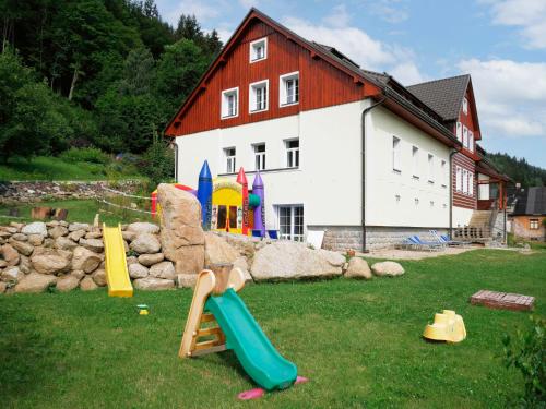 a group of playground equipment in front of a house at Studio Vodopády Černá Desná by Interhome in Desná