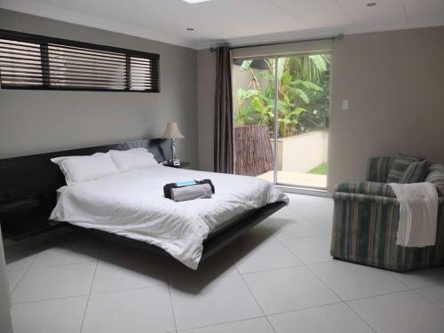 a bedroom with a bed with a suitcase on it at Korsmans Retreat - Large Modern Self-Catering Flat in Benoni