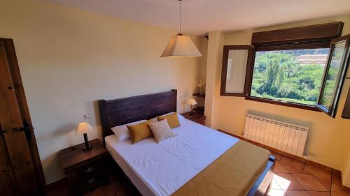 a bedroom with a large bed with a window at Casa Rural La Posada de Santa Teresa in Pastrana