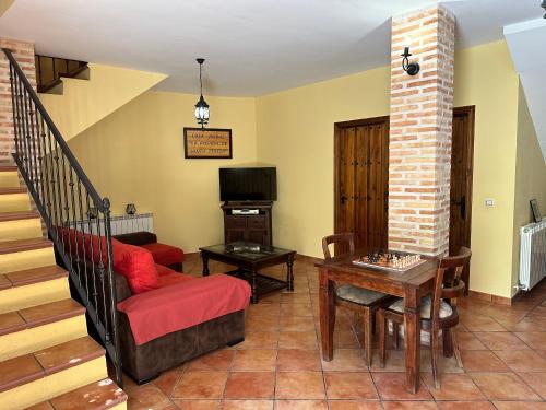 a living room with a red couch and a table at Casa Rural La Posada de Santa Teresa in Pastrana