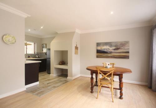 a kitchen and dining room with a table and chairs at Stony Brook Cottages in Franschhoek