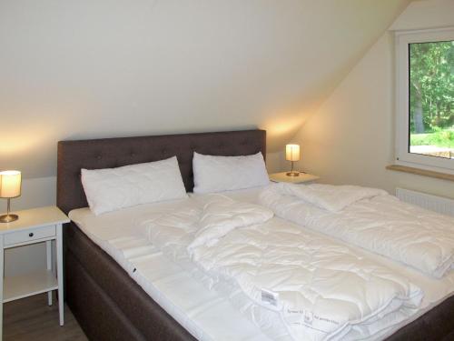a large bed in a room with two night stands at Apartment Müritz Ferienpark Röbel-21 by Interhome in Röbel