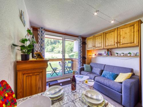 a living room with a couch and a table at Studio Soyouz Vanguard-97 by Interhome in Le Corbier