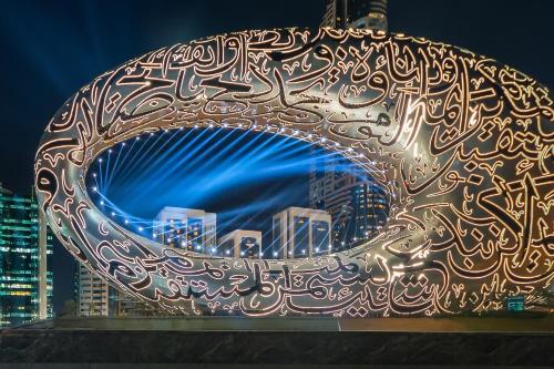 una ciotola di metallo con sopra una scritta di fronte a una città di Millennium Plaza Downtown, Dubai a Dubai