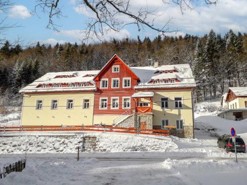 uma casa com um telhado vermelho na neve em Apartment Rašeliniště by Interhome em Desná