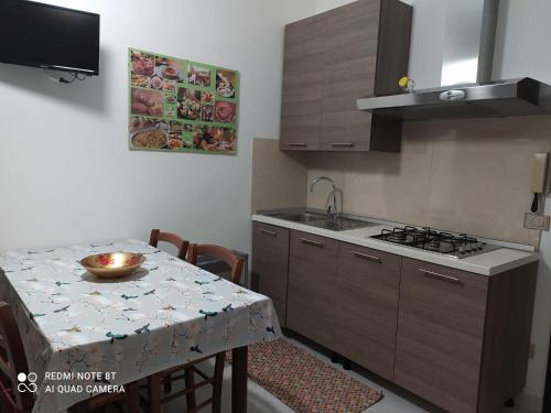 a kitchen with a table and a sink and a stove at Casa Vacanze Villa Verde - Ribera in Ribera