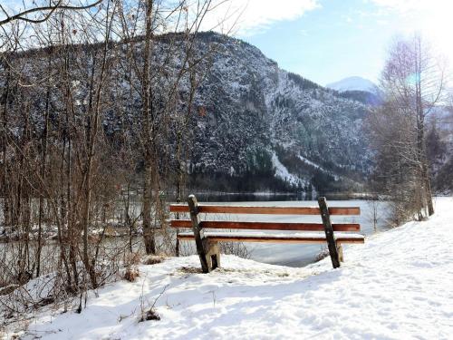 eine Bank im Schnee vor einem Berg in der Unterkunft Apartment Hasenstall - Top 8 by Interhome in Grünau im Almtal