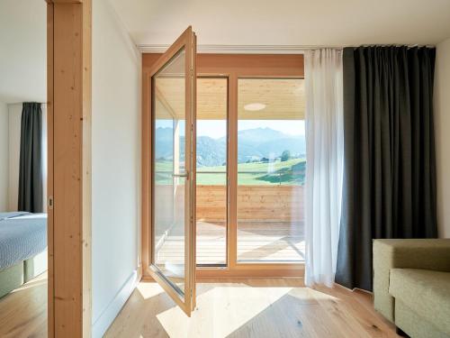 a bedroom with a large glass door leading to a balcony at Apartment Catrina 2-Zimmer Standard Apartment by Interhome in Disentis