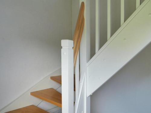 a staircase with white walls and wooden floors at Apartment Rosabel - 1km from the sea in NW Jutland by Interhome in Skagen