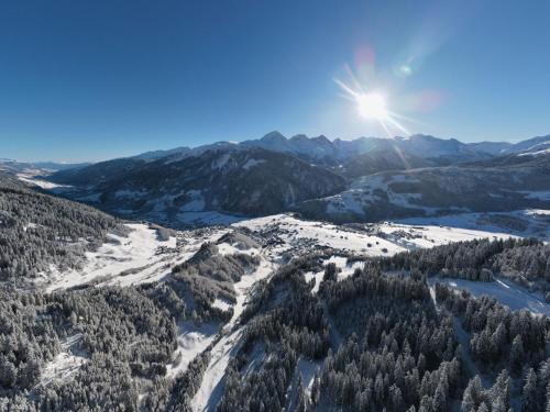 a view of a snowy mountain range with the sun in the sky at Apartment Catrina 3-Zimmer Premium Apartment by Interhome in Disentis