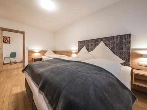 Un dormitorio con una cama grande con una manta negra. en Apartment Montec-3 by Interhome, en Hippach