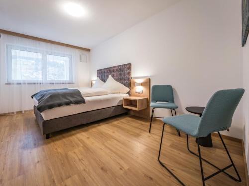 1 dormitorio con 1 cama y 2 sillas en Apartment Montec-3 by Interhome, en Hippach