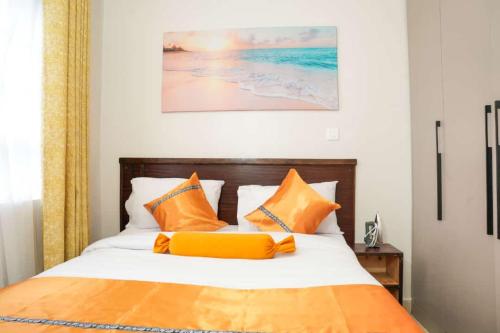 um quarto com uma cama com almofadas laranja e branca em Kelly homes in Naivasha em Naivasha