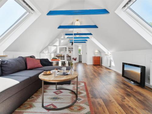 ein Wohnzimmer mit einem Sofa und einem Tisch in der Unterkunft Apartment Riitta - 250m from the sea in Bornholm by Interhome in Neksø