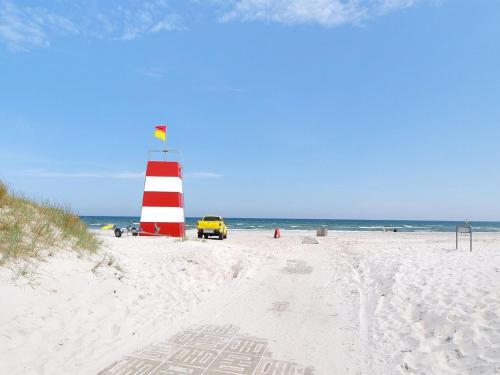 a red and white lighthouse on a sandy beach at Apartment Riitta - 250m from the sea in Bornholm by Interhome in Neksø