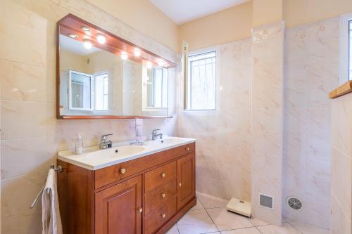 La salle de bains est pourvue d'un lavabo, d'un miroir et d'une douche. dans l'établissement Villa Ventiseri - Maison vue montagne, à Ventiseri