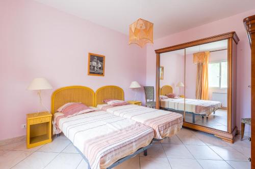 een slaapkamer met 2 bedden en een spiegel bij Villa Ventiseri - Maison vue montagne in Ventiseri