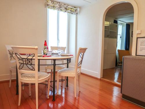 Apartment Petit nid de Pully by Interhome في كولي: غرفة طعام مع طاولة وأربعة كراسي