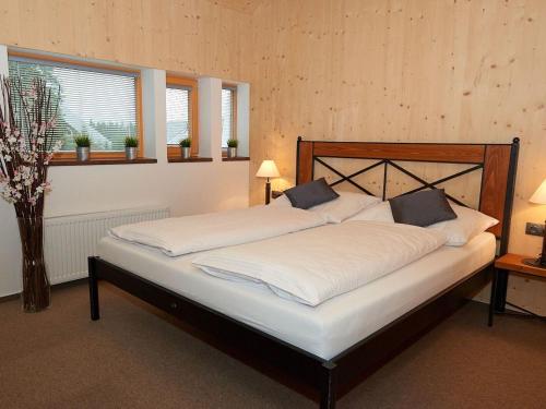 een slaapkamer met een groot bed met witte lakens bij Chalet Harrachov 670 by Interhome in Harrachov