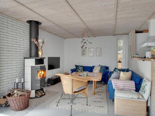 - un salon avec un canapé bleu et une cheminée dans l'établissement Holiday Home Solvejk - 1-5km to the inlet in Sealand by Interhome, à Nykøbing Sjælland